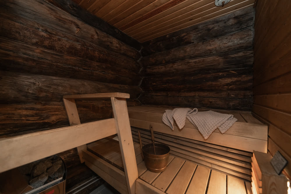 Traditional wood sauna with bench and bucket